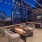chairs around rooftop fire pit with city views