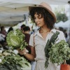 lifestyle image of a woman looking at produce at a farmers market